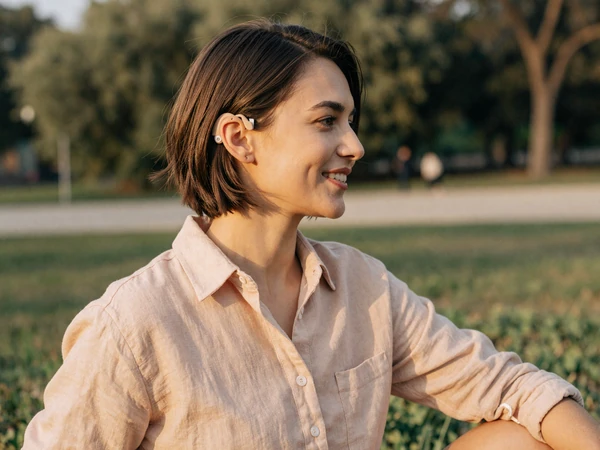 Hannah, a cochlear implant user on InclusiveDating, smiling in golden hour park light