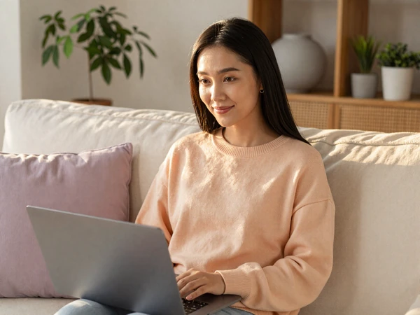 Maya, a young Asian American woman, browsing an ADHD-friendly dating app on her laptop at home